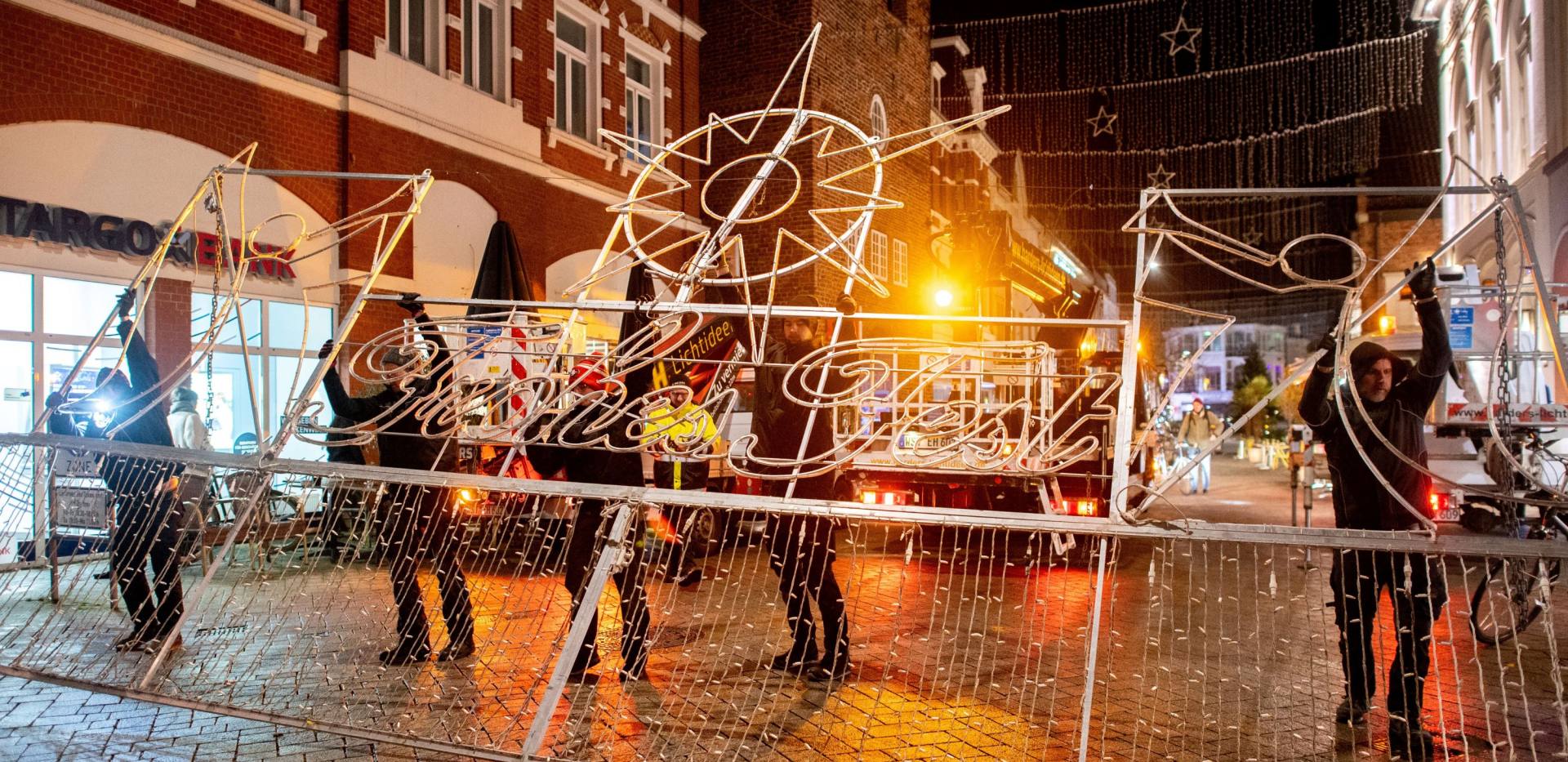 Mitarbeitende von Harders Lichtideen hängen die Weihnachtsbeleuchtung am Lappan auf.